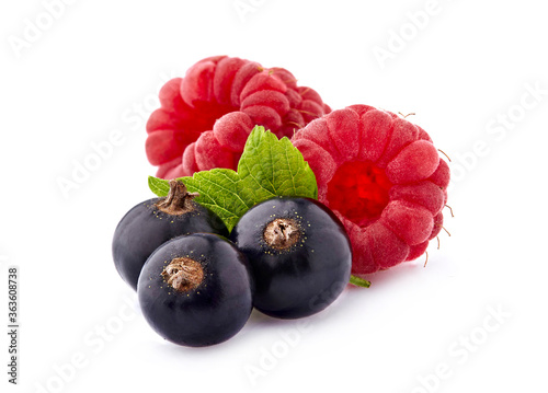 Black currant berries with raspberries on White Background. Ripe berries isolated.