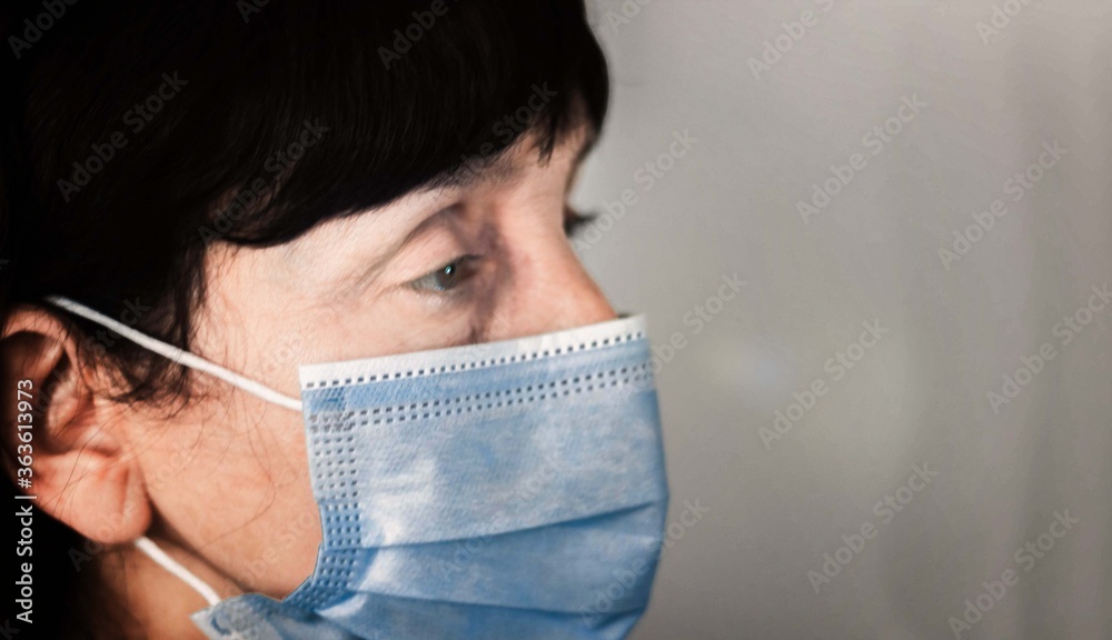 Coronavirus quarantine and Air pollution pm2.5 concept. Face of old sick woman wearing blue respirator mask for protect. Wuhan, China epidemic virus symptoms background. Coronavirus quarantine and Air pollution pm2.5 concept. Face of old sick woman wearing blue respirator mask for protect. Wuhan, China epidemic virus symptoms background.