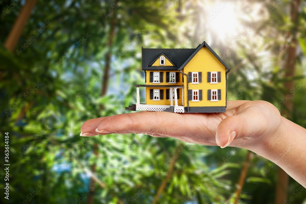 Real estate property concept. Hands holding house model
