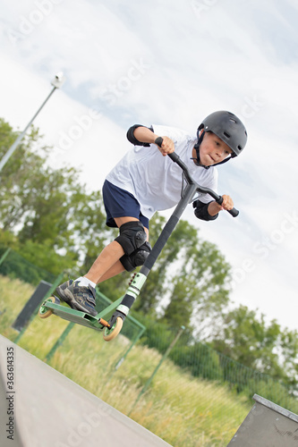 Obraz na płótnie The boy jumps on a scooter. w salonie