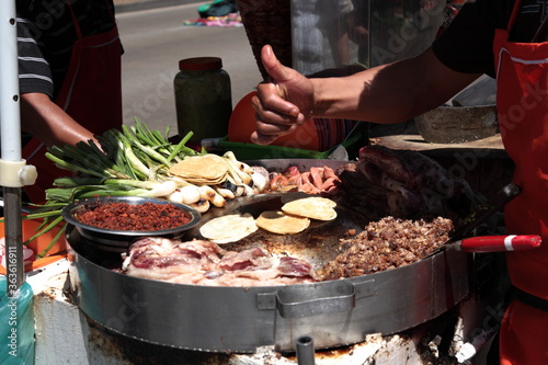 Street Food rich Tacos with toppings and thumbs up in downtown Mexico city