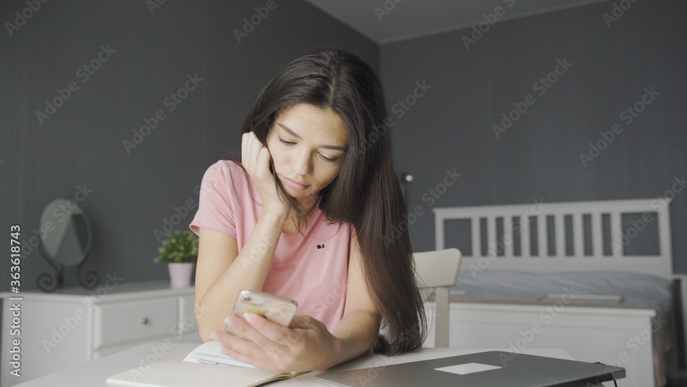 Young beautiful woman using phone while at home. Young beautiful woman using phone while at home.