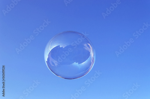 large round soap bubble floating in the blue sky