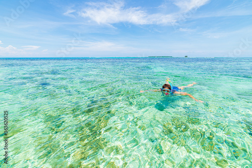 Woman snorkeling in caribbean on coral reef tropical turquoise blue water. Indonesia Wakatobi archipelago, marine national park, tourist diving travel destination