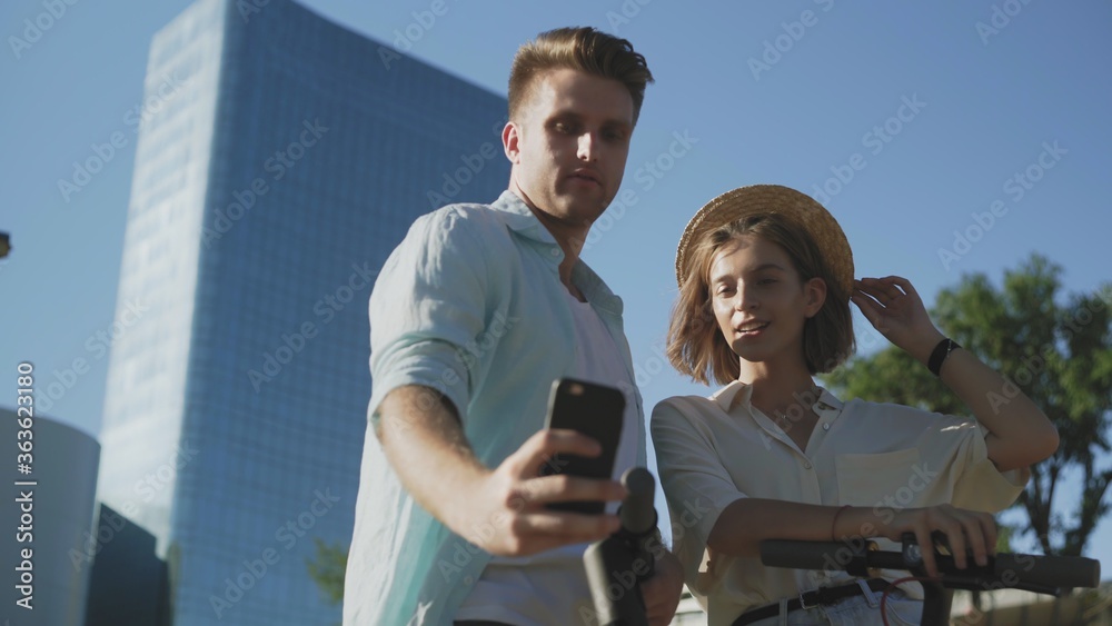 Couple Making Photo On Mobile Phone in the summer park Couple Making Photo On Mobile Phone in the summer park