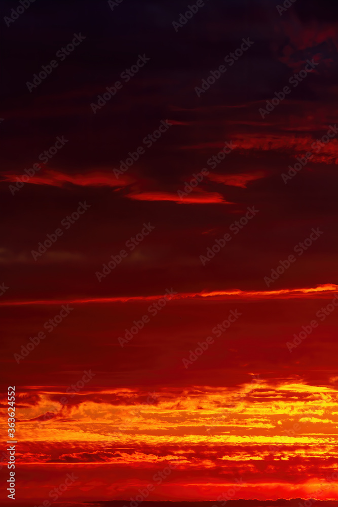 Dark orange sunset. Blurry picturesque sky. Beautiful vertical natural background.