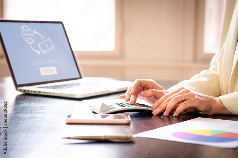 Businesswoman's hand while using using calculator at office desk Businesswoman's hand while using using calculator at office desk