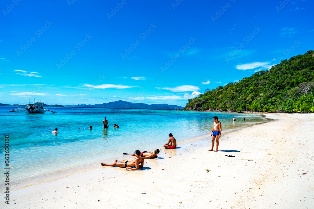 Coron, Philippines - January 3, 2020: People relaxing on Malcapuya Island, Coron, Philippines.