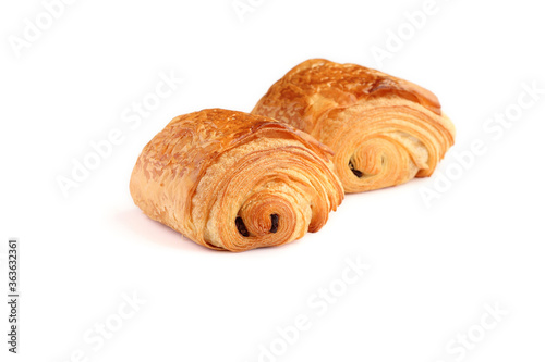 Two french traditional croissants with  two pieces of dark chocolate in the centre called Petit pain au chocolat  isolated on white background.