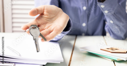 Real Estate Agent Gives The Keys To The House Buyer And Signs The Contract In The Office.