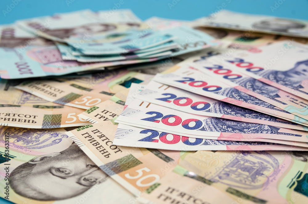 Ukrainian hryvnia on a blue background. Much money. Ukrainian hryvnia on a blue background. Much money.