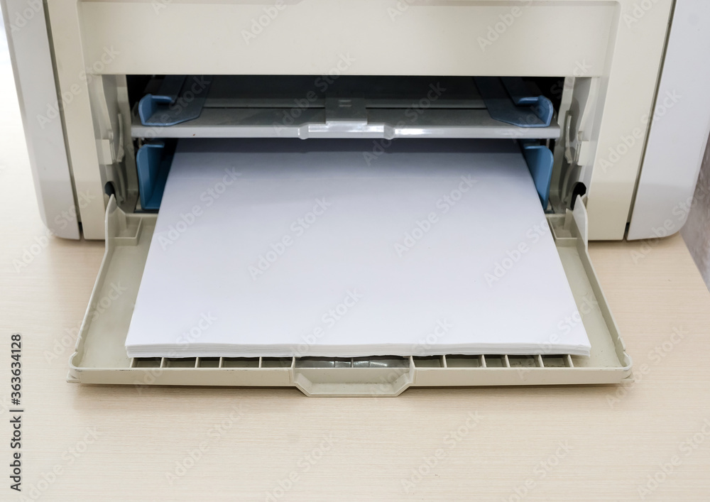gray printer with white paper on the office desk. Close-up. gray printer with white paper on the office desk. Close-up.