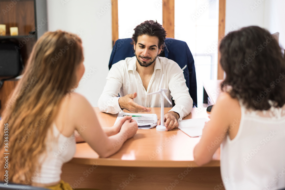 Salesperson at office talking with a couple of women Salesperson at office talking with a couple of women