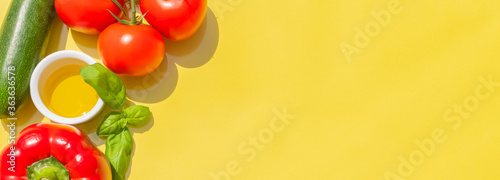 Présentation créative de légumes de saison de l'été avec tomates, courgette, poivron rouge, huile d'olive et basilic frais. Sur fond pour inclure un texte.	 photo