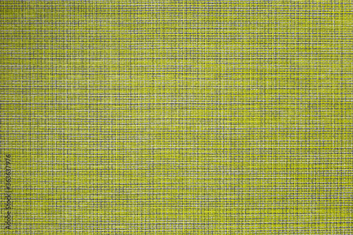 The table mat is yellow, woven from thin plastic rods.