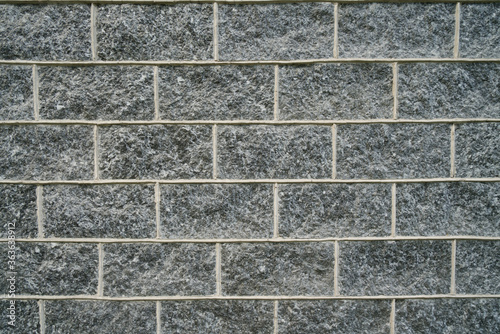 wall of dark natural stone bricks texture, dark gray surface