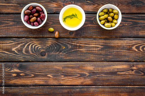 Olive oil in bowl near oilves from above copy space