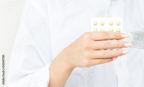 Woman Taking Medicine. Beautiful Young Female Holding Blister Pack With Pills In Hand And Reading Medical Instructions. Attractive Girl Looking At Instruction, Holding Pill Package. High Resolution