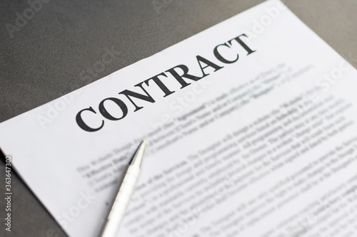 Business Contract and pen close up on grey background