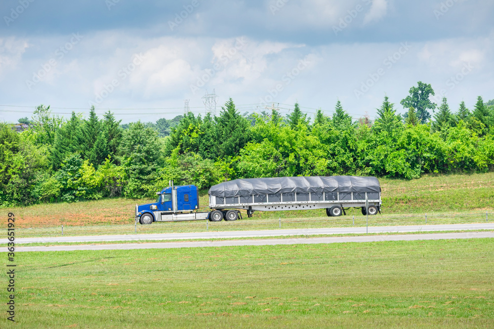 Fototapeta premium Blue 18-Wheeler With Covered Bed Travels A Tennessee Highway