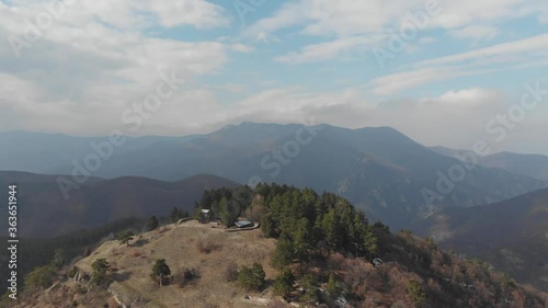 The peaks of high mountains are covered with dense forests. Panoramic view of the valley at the 
foot of the mountains.