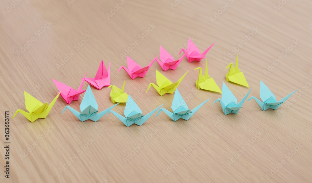 Origami cranes flocking in line