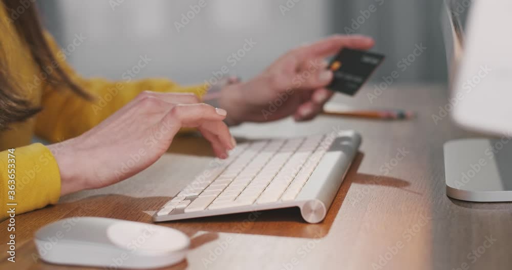Close up shot of Caucasian female hands typing on keyboard and using computer mouse while sitting at desk and buying online. Woman fingers tapping while paying with credit card on internet Buy concept Close up shot of Caucasian female hands typing on keyboard and using computer mouse while sitting at desk and buying online. Woman fingers tapping while paying with credit card on internet Buy concept
