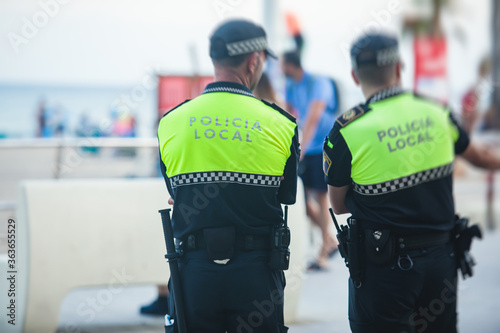 Obraz na plátně Spanish police squad formation back view with Local Police logo emblem on unif