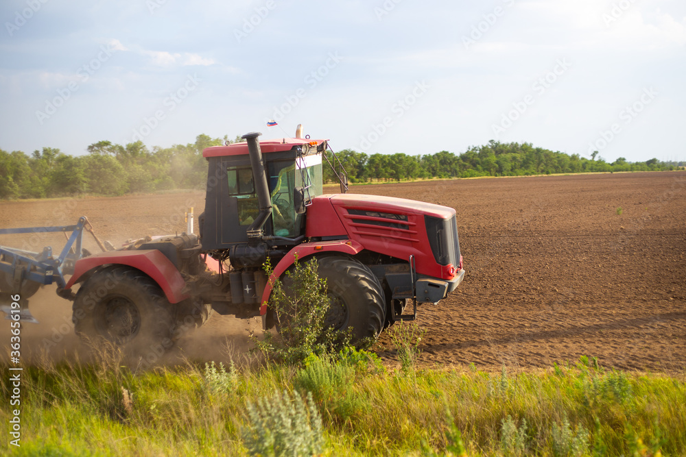 tractor plows the land for sowing, with a plow on a sunny day, agriculture tractor plows the land for sowing, with a plow on a sunny day, agriculture