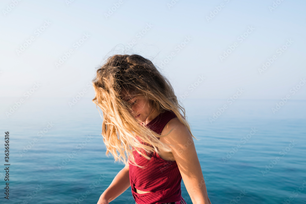 Young blonde woman portrait against deep blue sea Young blonde woman portrait against deep blue sea
