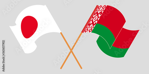 Crossed and waving flags of Belarus and Japan