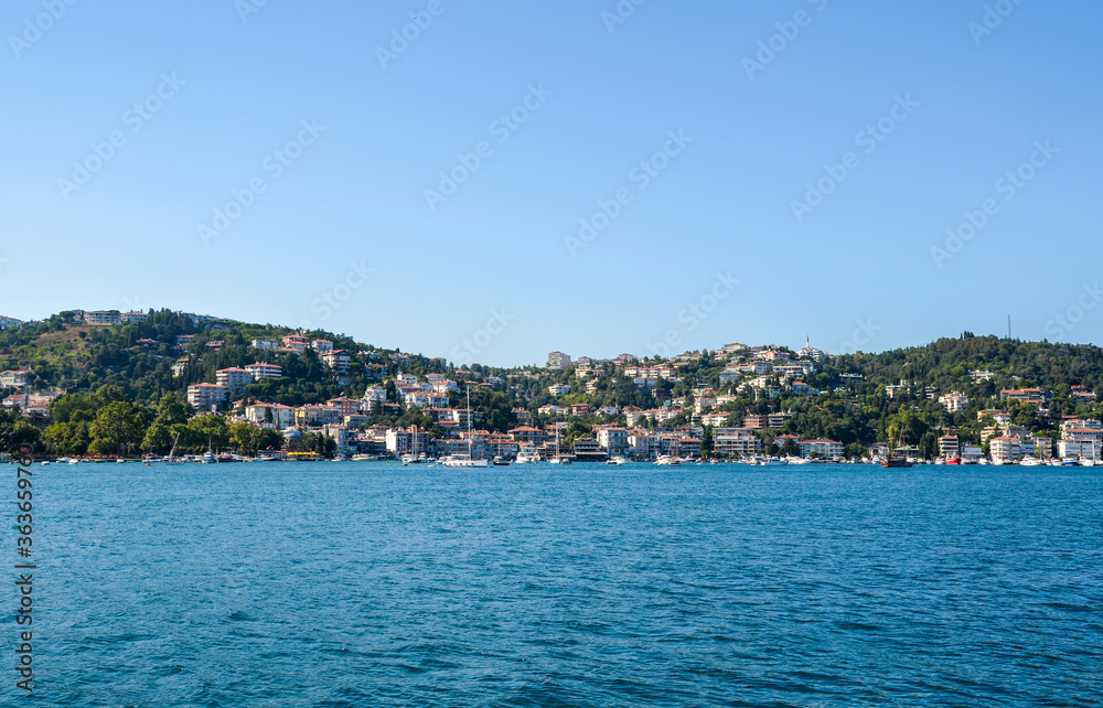 Beautiful view of the residential area, hillside waterfront colorful houses and a park from the Bosphorus Strait in Istanbul, Turkey.