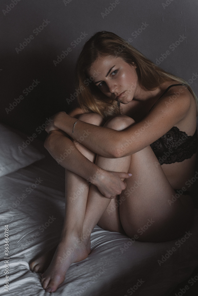 Beautiful young woman hugging her knees and looking away. Beautiful young woman hugging her knees and looking away.
