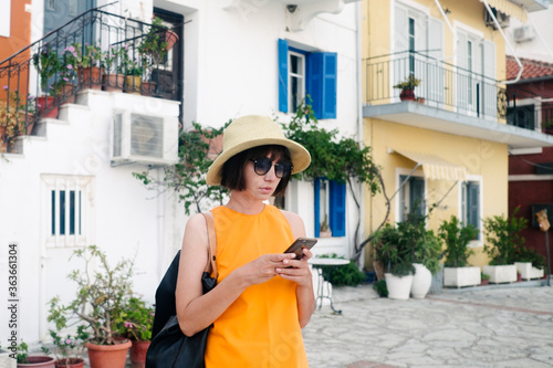 Female model with hat and sunglasses using her mobile phone on vocation photo