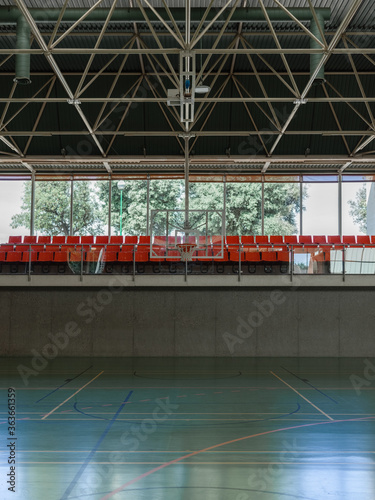 School gym with basketball ring and bleachers
