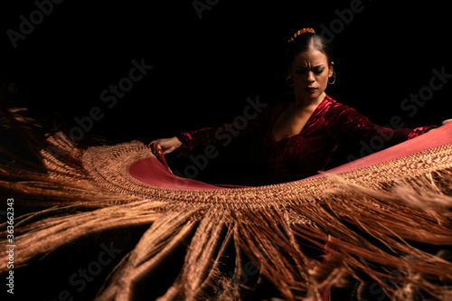 Young woman dancing flamenco on black photo