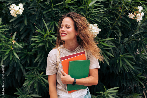 Female student carrying notebooks