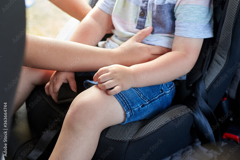 Mom sits her son in a car seat. Mom sits her son in a car seat.