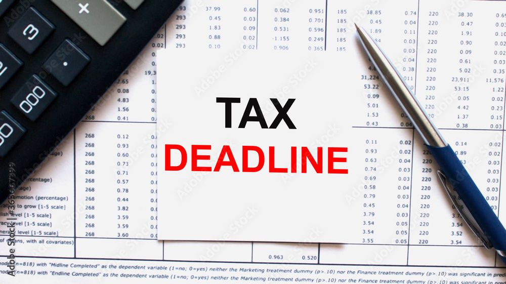 Work smarter text Tax Deadline on white sheet with pen, calculator and tables Work smarter text Tax Deadline on white sheet with pen, calculator and tables