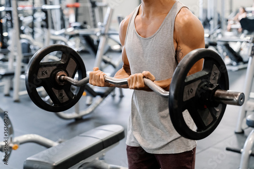 Attractive asian man lifting weight at the gym. photo