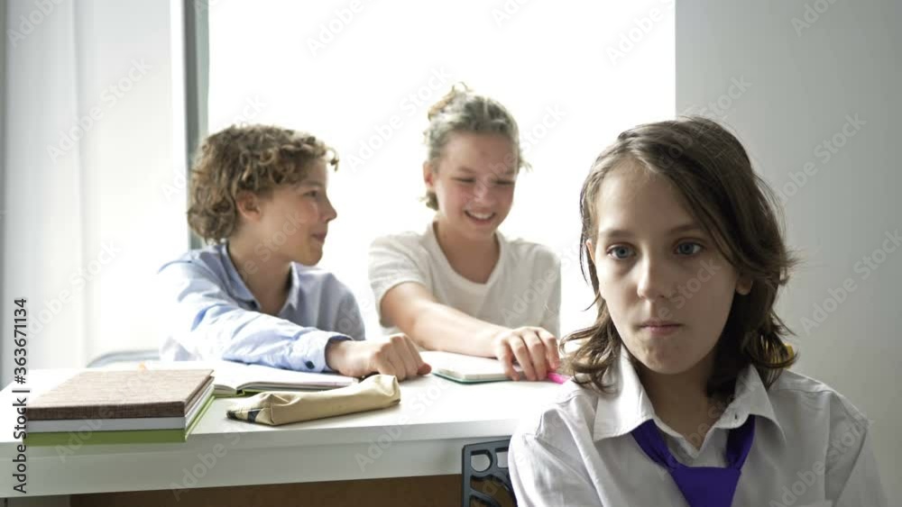 Two teens scoff at their defenseless classmate. Child cruelty. School bullying. Two teens scoff at their defenseless classmate. Child cruelty. School bullying.