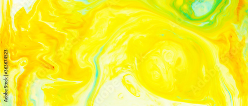 Fluid Art. Abstract blurred colorful background. Swirl liquid pattern. Marble effect of yellow color. Trendy colorful backdrop. Mixing paints