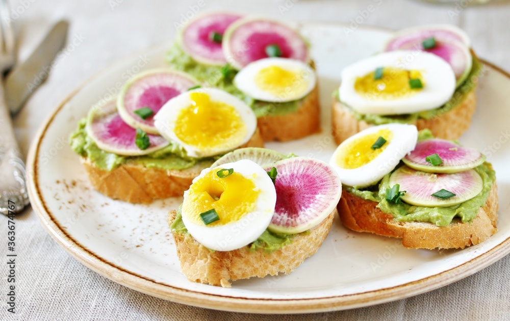 watermelon radish sandwich with avocado and egg. healthy balanced breakfast. bright toast
