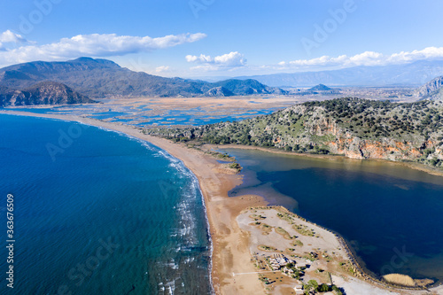 Fototapeta Naklejka Na Ścianę i Meble -  iztuzu long beach gorgeous mountains reeds field and wavy sea, aerial landscape view. iztuzu beach Mugla Province, village of Dalyan in Turkey. 
