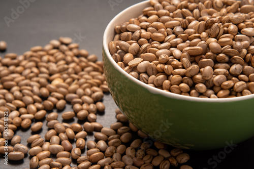 Carioquinha type beans over black background. Brazilian beans. Top view