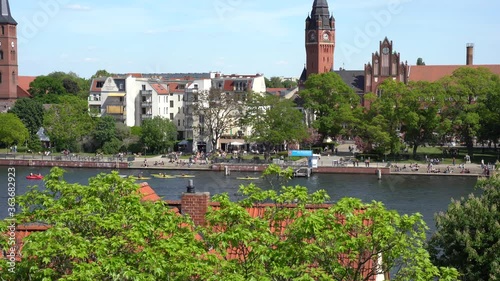 District Köpenick in Berlin, Germany crowd of people outdoor kayaking, boating and recreation in front of old town city hall park on river photo