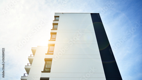 Modern apartment buildings on a sunny day with a blue sky. Facade of a modern apartment building. Glass surface with sunlight.