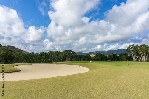 golf course in new caledonia with blue sky. Hills in the background 
