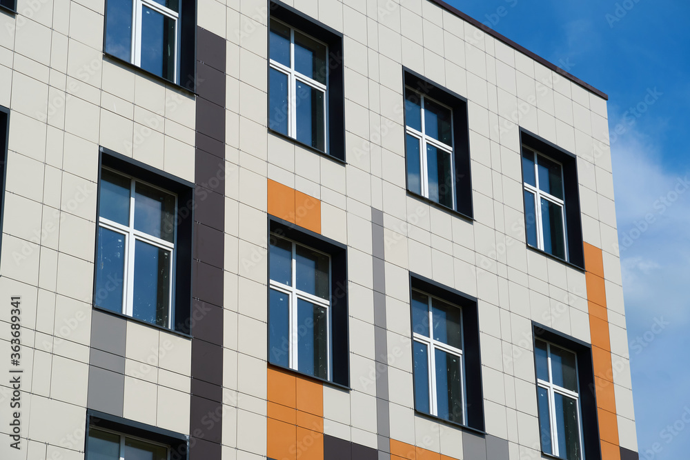 facade of a modern building on a bright Sunny day, siding and Windows, beautiful exterior of the new building