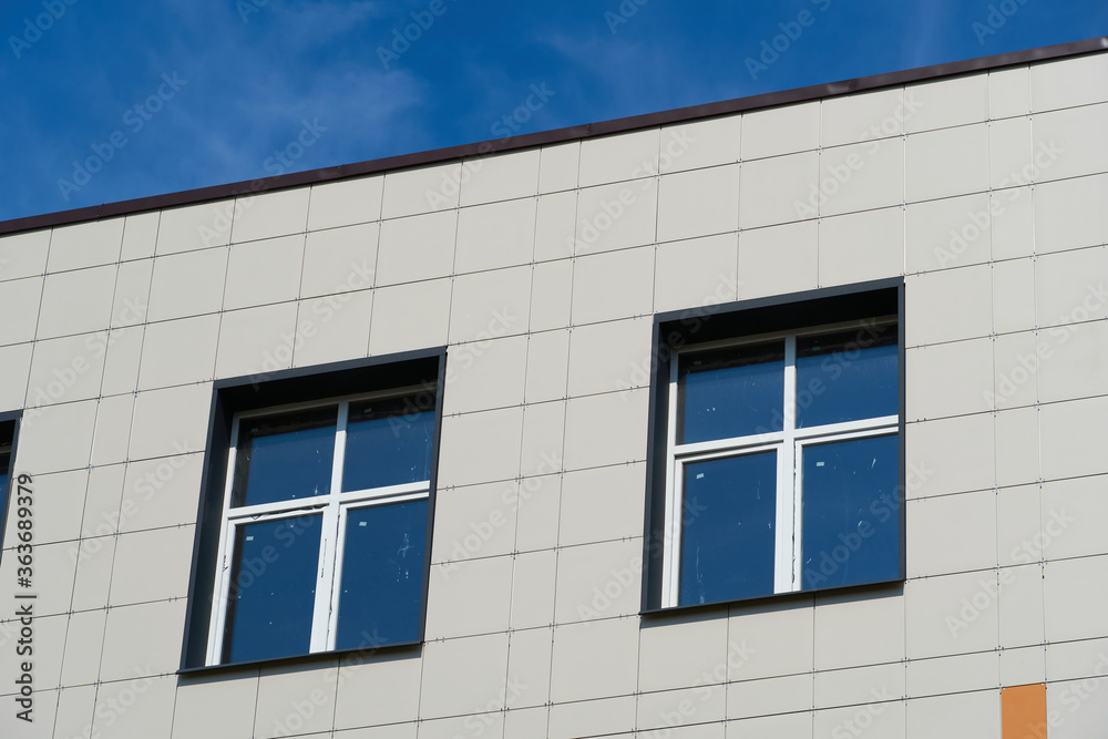 facade of a modern building on a bright Sunny day, siding and Windows, beautiful exterior of the new building facade of a modern building on a bright Sunny day, siding and Windows, beautiful exterior of the new building
